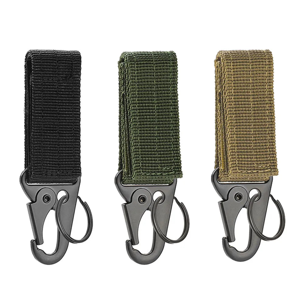 Three tactical carabiners with nylon straps in khaki, black, and green colors, attached to a backpack.