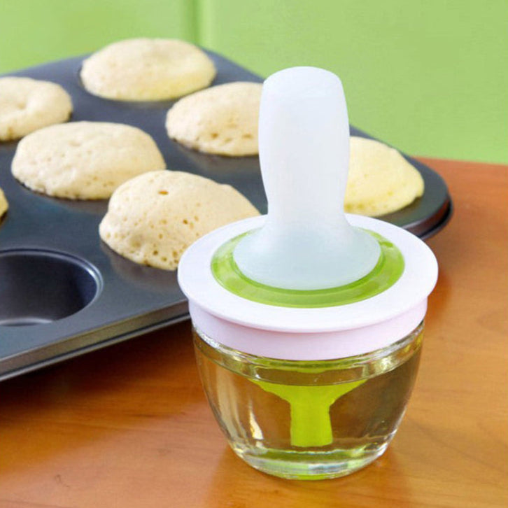 Baking tool with a funnel-like top on a wooden surface next to a muffin tin with baked muffins.